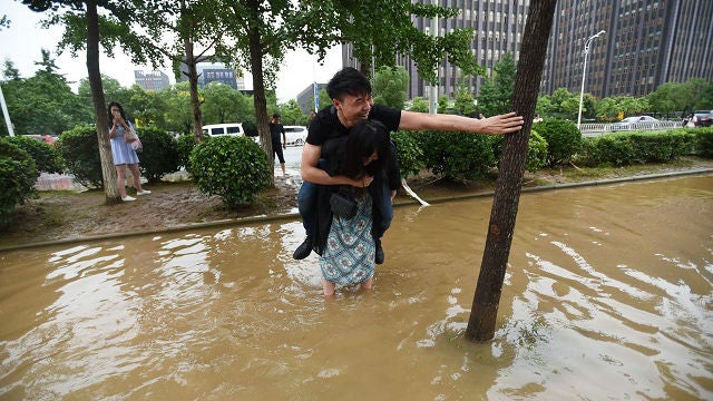 Chinese Girlfriend Carries Boyfriend Over Flood Waters To Save His Leather Shoes - World Of Buzz 1