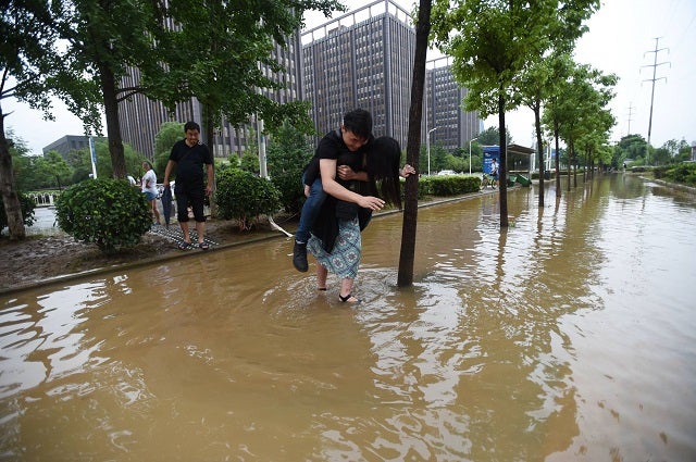 Chinese Girlfriend Carries Boyfriend Over Flood Waters To Save His Leather Shoes - World Of Buzz 2
