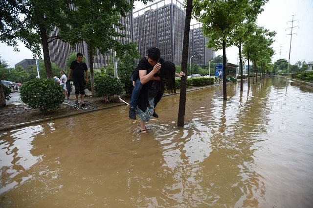 Chinese Girlfriend Carries Boyfriend Over Flood Waters To Save His Leather Shoes - World Of Buzz 4