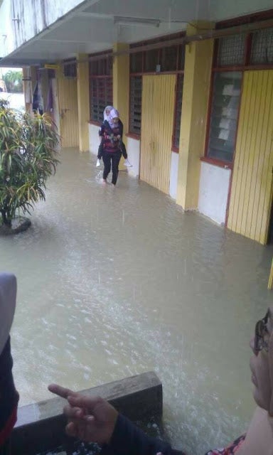 Amazing Malaysian Teacher Carries Schoolchildren Across Flood Waters to Safety - WORLD OF BUZZ 1