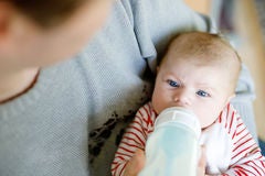 father feeding newborn baby daughter milk nursing bottle formula drink babies new born child little girl laying bed 87579921