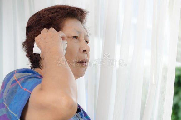 Asian Senior Woman Using Phone Call Near Window Home Asian Senior Woman Using Phone Call Near Window Home 98973699