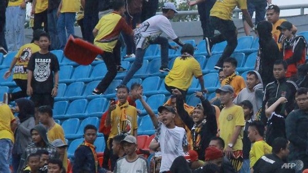 irate spectators throw chairs ripped from the stands during the league football match between sriwijaya fc and arema fc at indonesia s gelora sriwijaya stadium 1532249503380 4 e1532321493311