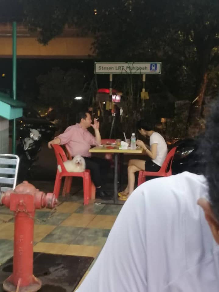Man Criticised For Smoking At The Mamak With His Dog Seating On A Chair Beside Him - World Of Buzz