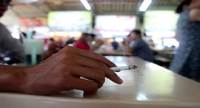 Smoker uses a measuring tape to smoke 3 meters away from a restaurant - WORLD OF BUZZ 1