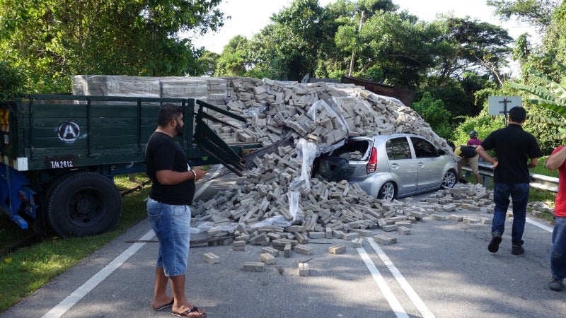 Lorry's Stalled Engine Causes It to Reverse, Heavy Load of Bricks Spill & Land on Perodua Myvi - WORLD OF BUZZ