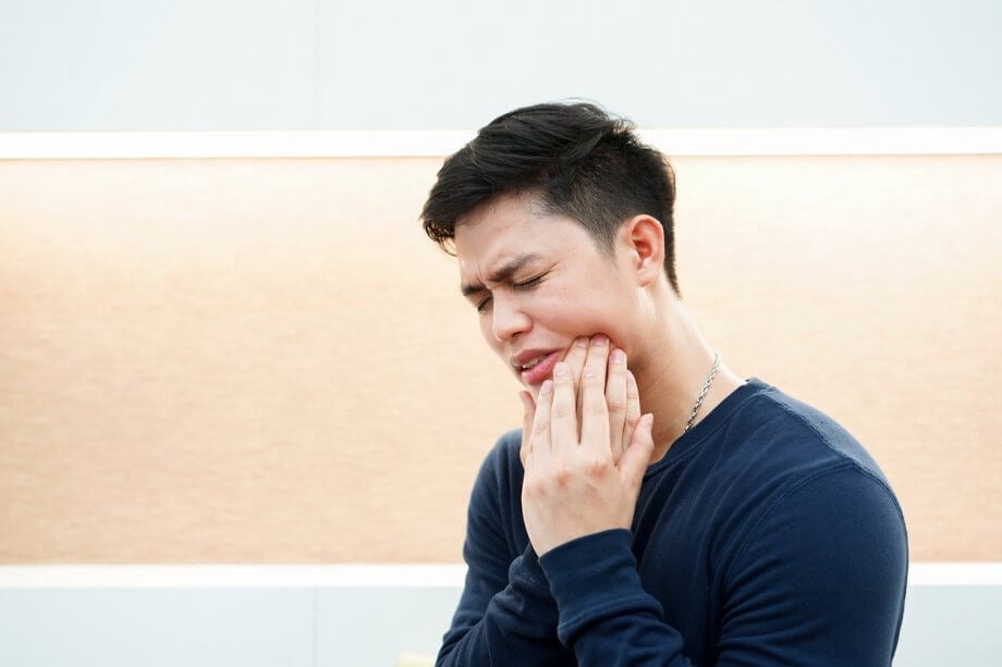 man in pain from wisodom tooth infection