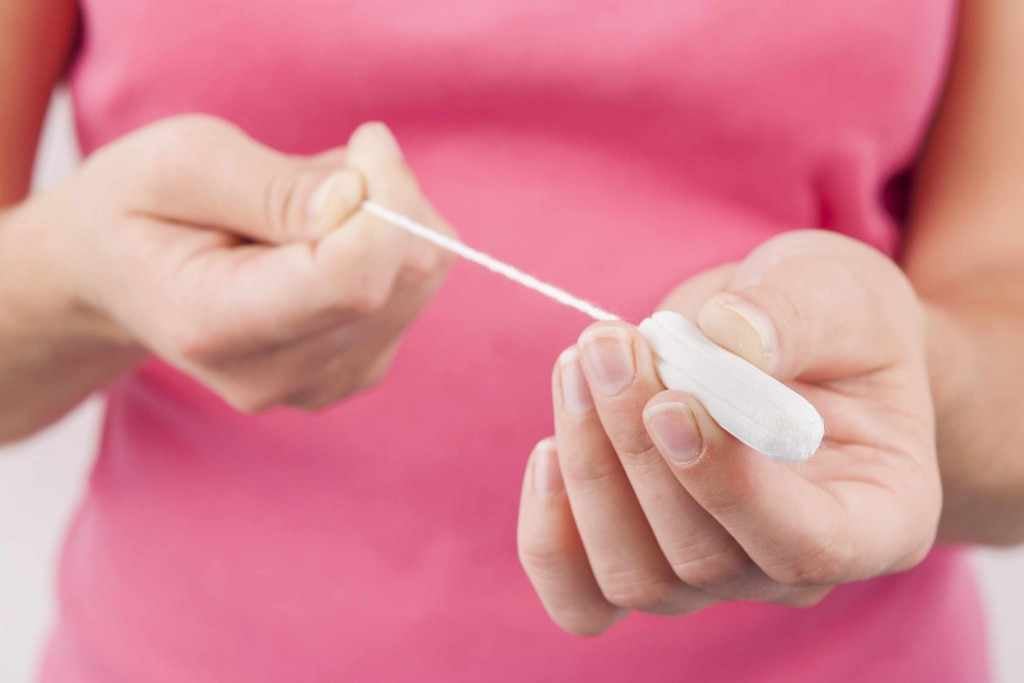 young woman holding a tampon in her hand menstrual period