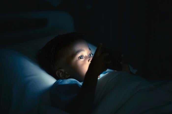 Child looking at screen in dark room before bed HRAUN Getty Images large