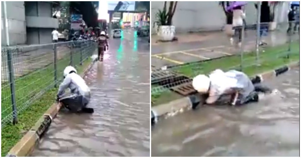 Watch: Dedicated KL Police Unclogs Drain Using His Own Hand During Flash Flood - WORLD OF BUZZ