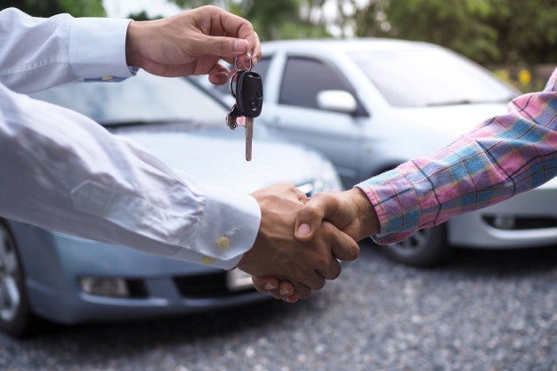 car salesman is handing keys buyer after lease has been agreed 112699 642