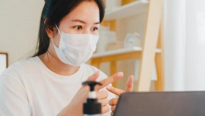 asian business woman wearing mask during video call at home free photo