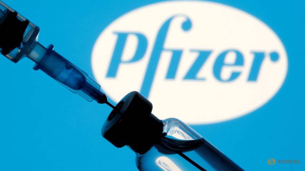 file photo vial and sryinge are seen in front of displayed pfizer logo 1