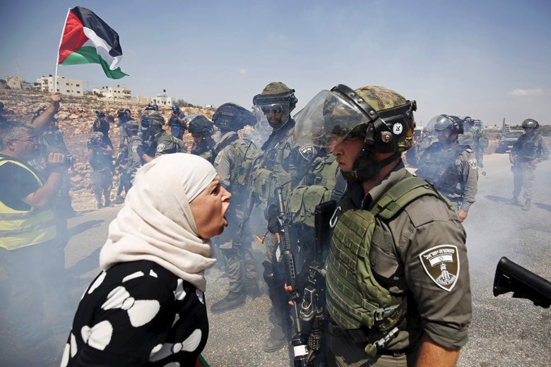 palestinian woman argues with israeli border policeman west bank