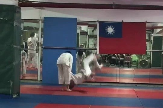 Judo coach throwing student to the ground