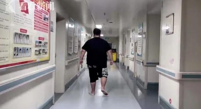 Obese man walking in hospital corridor