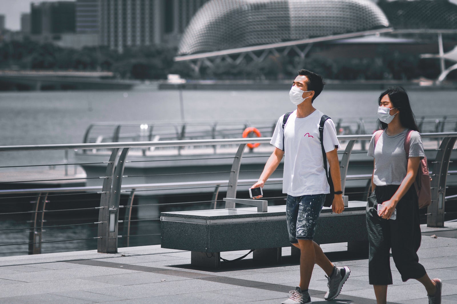 man and woman walking in singapore with mask on