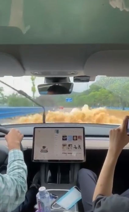 man driving tesla in china through flood