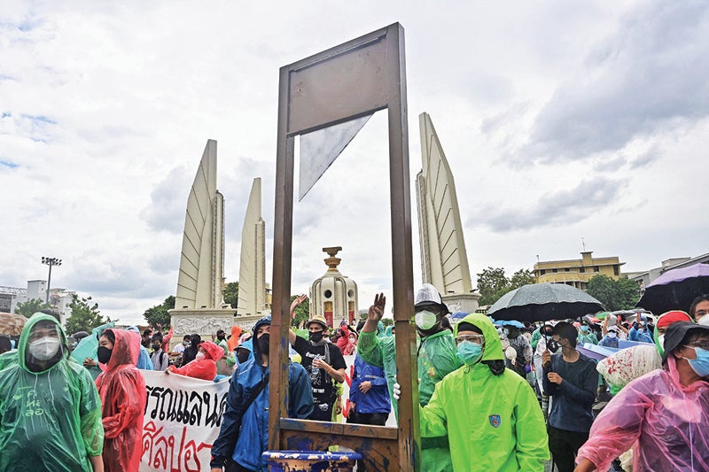 Thai Protesters Pushing A Fake Guillotine During March