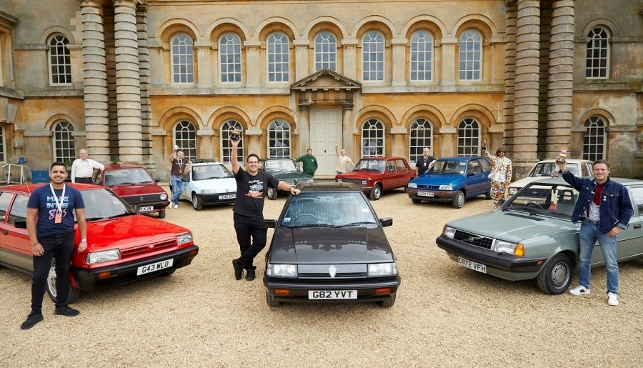 A group of people standing with their own vintage cars