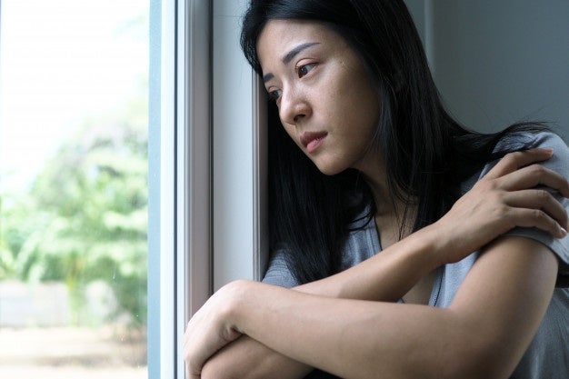 asian woman sitting inside house looking out window woman confused disappointed sad upset 112699 171 1