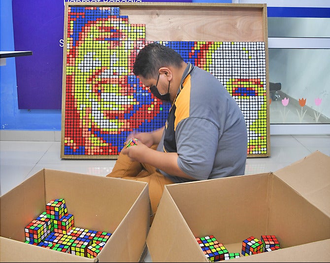man solving rubik cube e1629893125182
