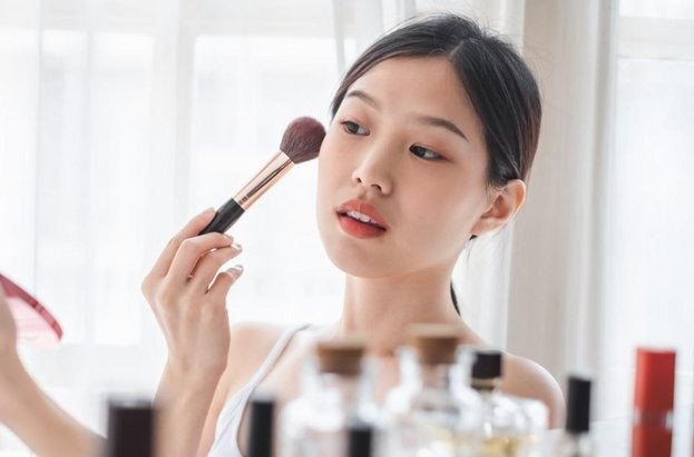young beautiful asian woman applying cosmetics make up on her face picture id1131272148 e1654652864376