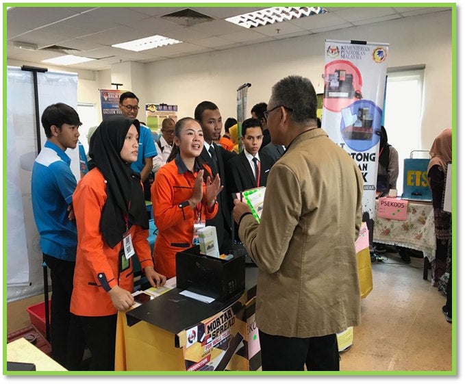 Photo in action Alesyah together with her team explaining their project at an innovation contest