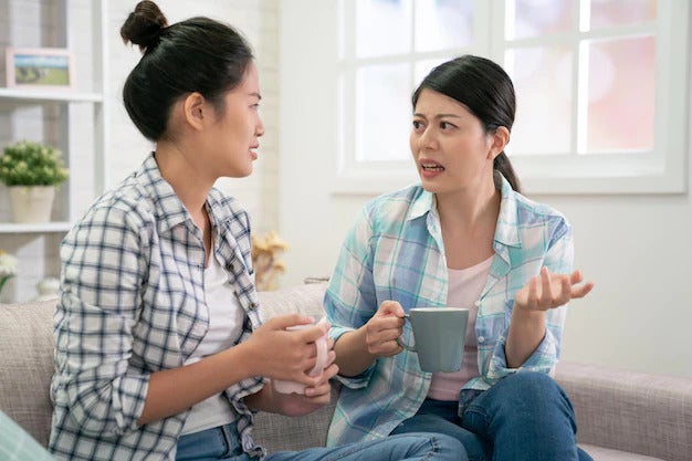concerned young girl talking with best friend sit couch having serious conversation asian chinese woman complaining sharing problems concern sister help dealing with depression hold cup 678158 252
