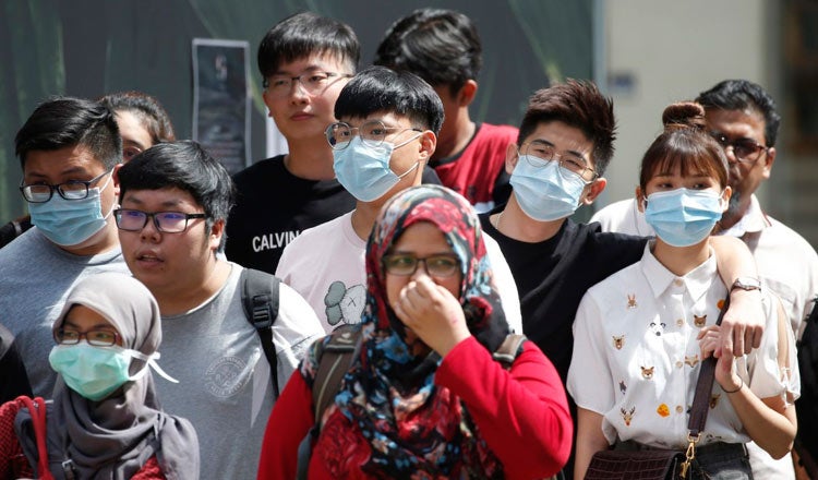 People wearing protective face mask waiting to crosss the road in Kuala Lumpur Malaysia on March 14 2020 1