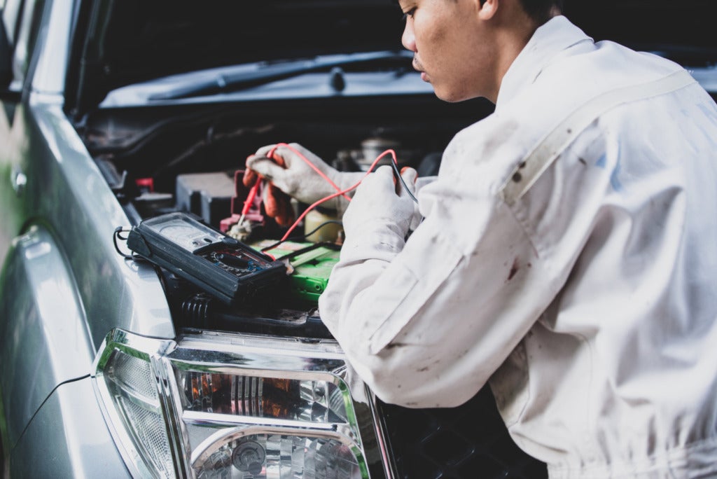 car repairman wearing white uniform standing holding wrench that is essential tool mechanic