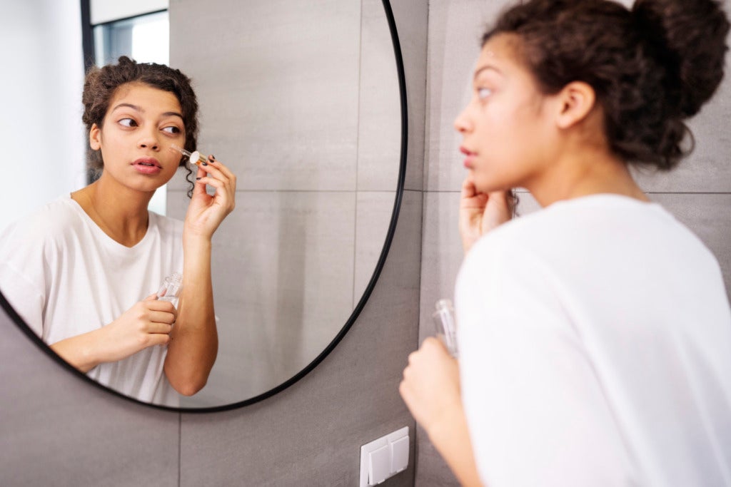Medium Shot Woman Applying Serum