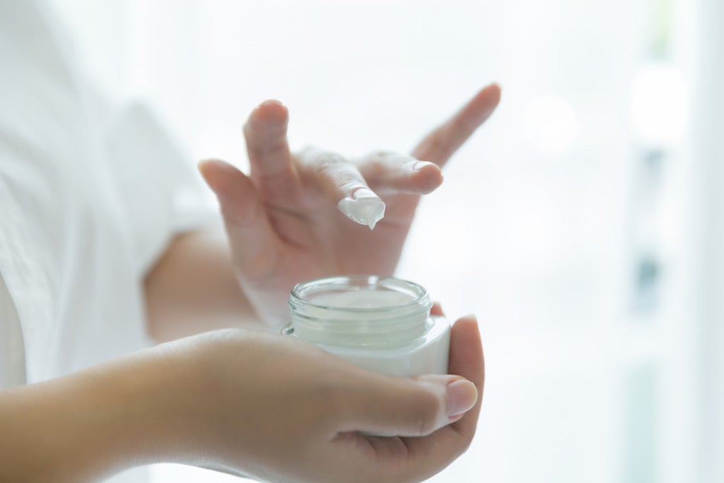 woman holds jar with cosmetic cream her hands