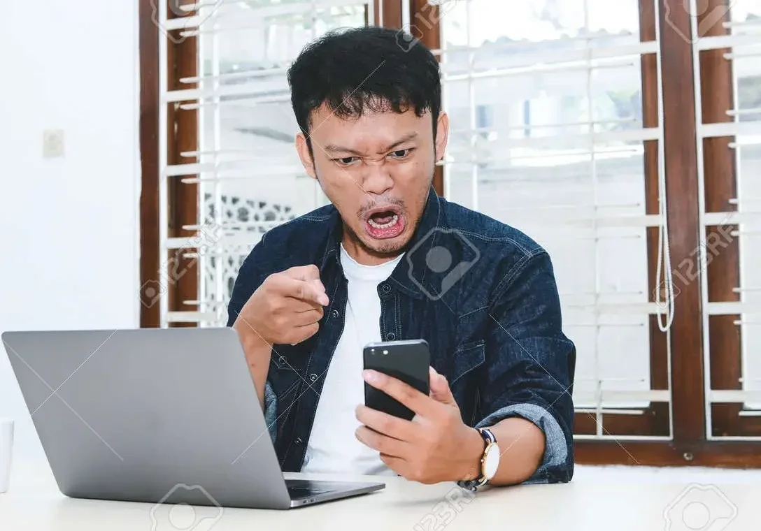 172194522 年轻的亚洲男子在工作时在笔记本电脑上看到的东西让他感到愤怒和疯狂 E1684131845931