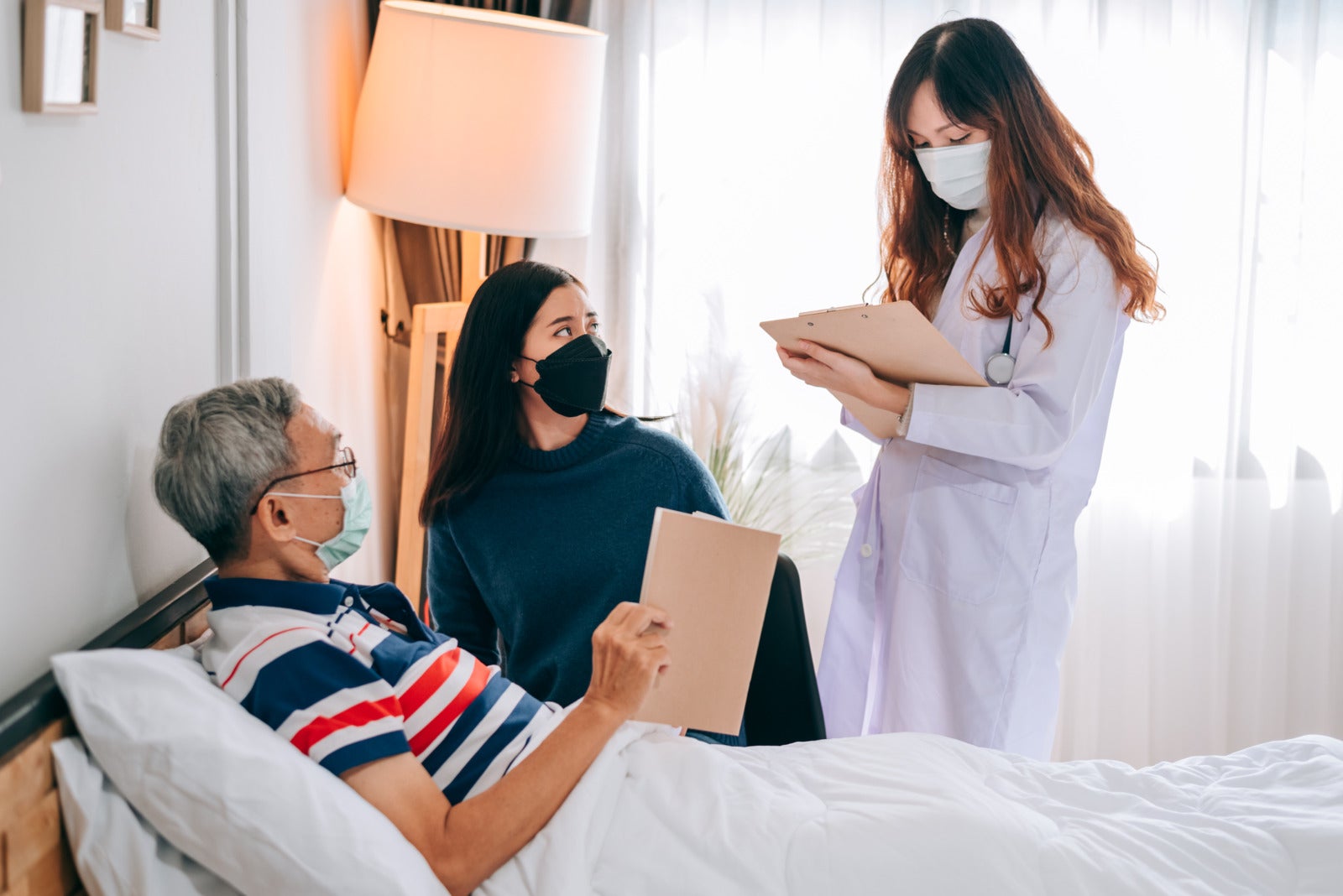 asian doctor visit examines senior man home doctor checking up consulting retirement health partienthospital services wearing mask protect covid19