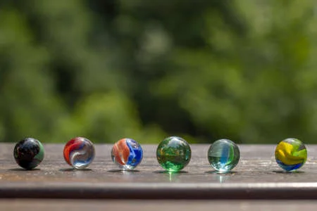 152677123 colorful marbles on the garden wooden table