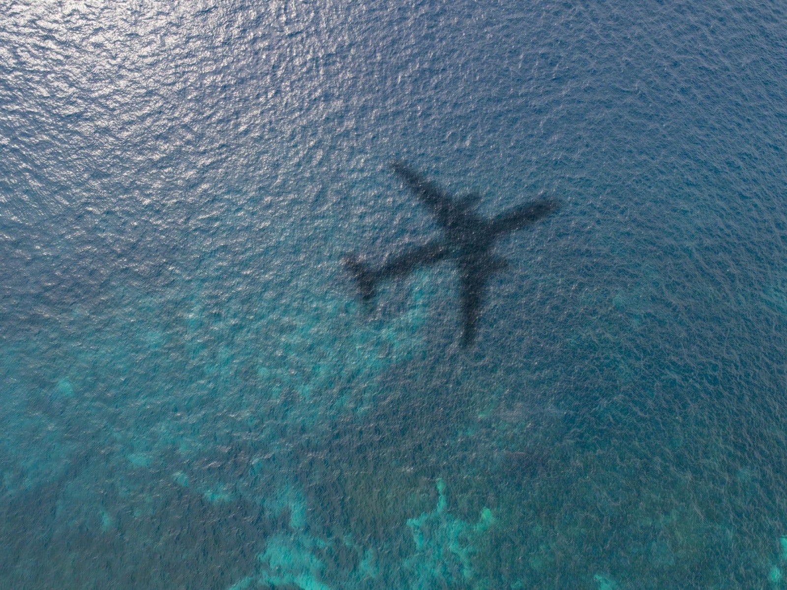 airplane shadow on the ocean royalty free image 1678119446