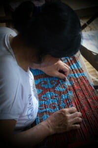 Nancy anak Ngali Iban ikat weaver tying the warp
