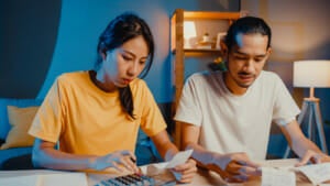 stress asian couple man woman use calculator calculate family budget