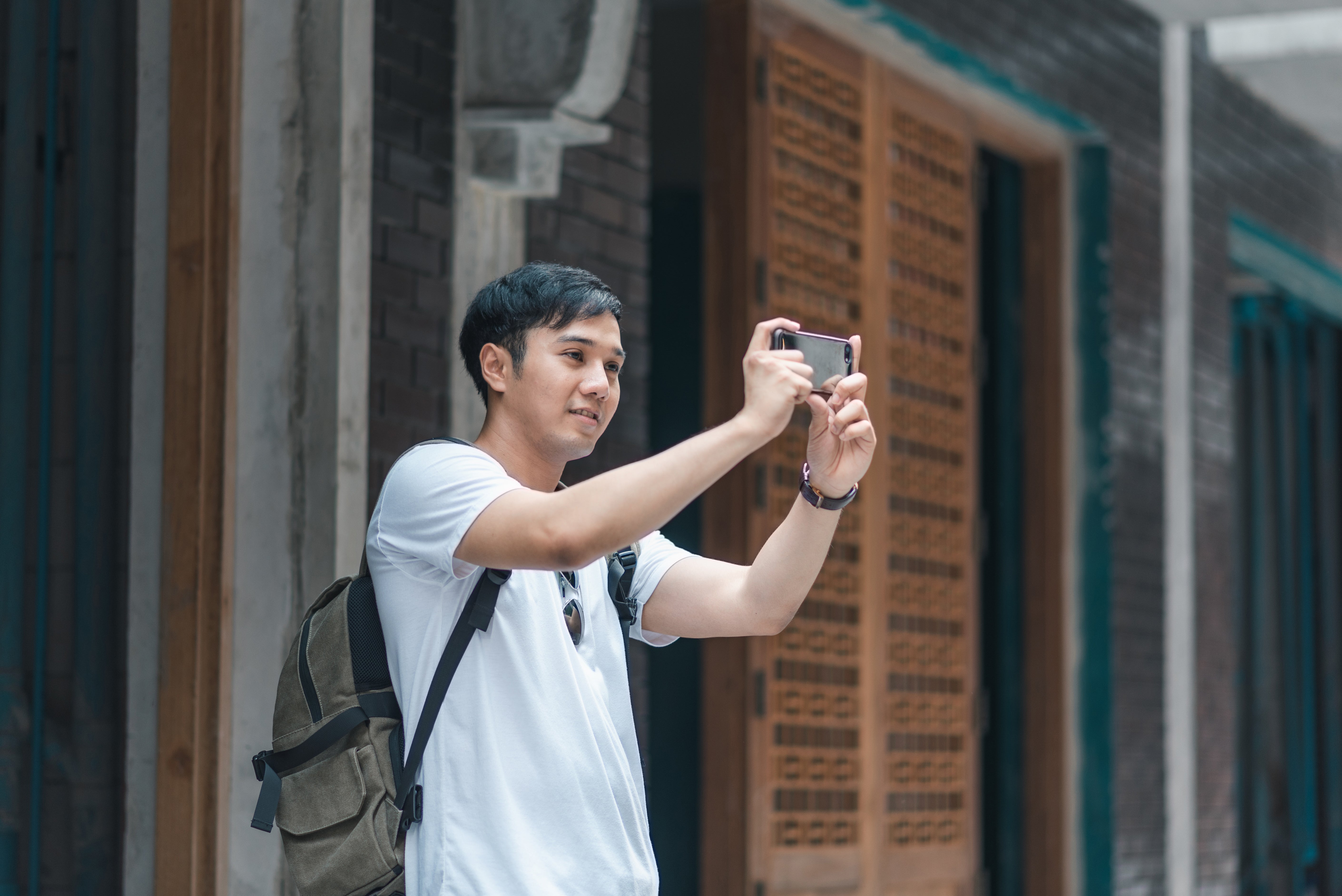 traveler asian man using mobile phone take picture while spending holiday trip beijing china