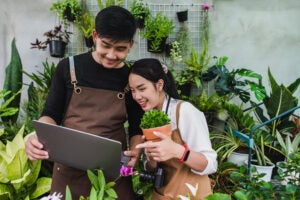 Portrait Asian Young Gardener Couple Wearing Apron Use Garden Equipment Laptop Computer Research Take Care House Plants Greenhouse