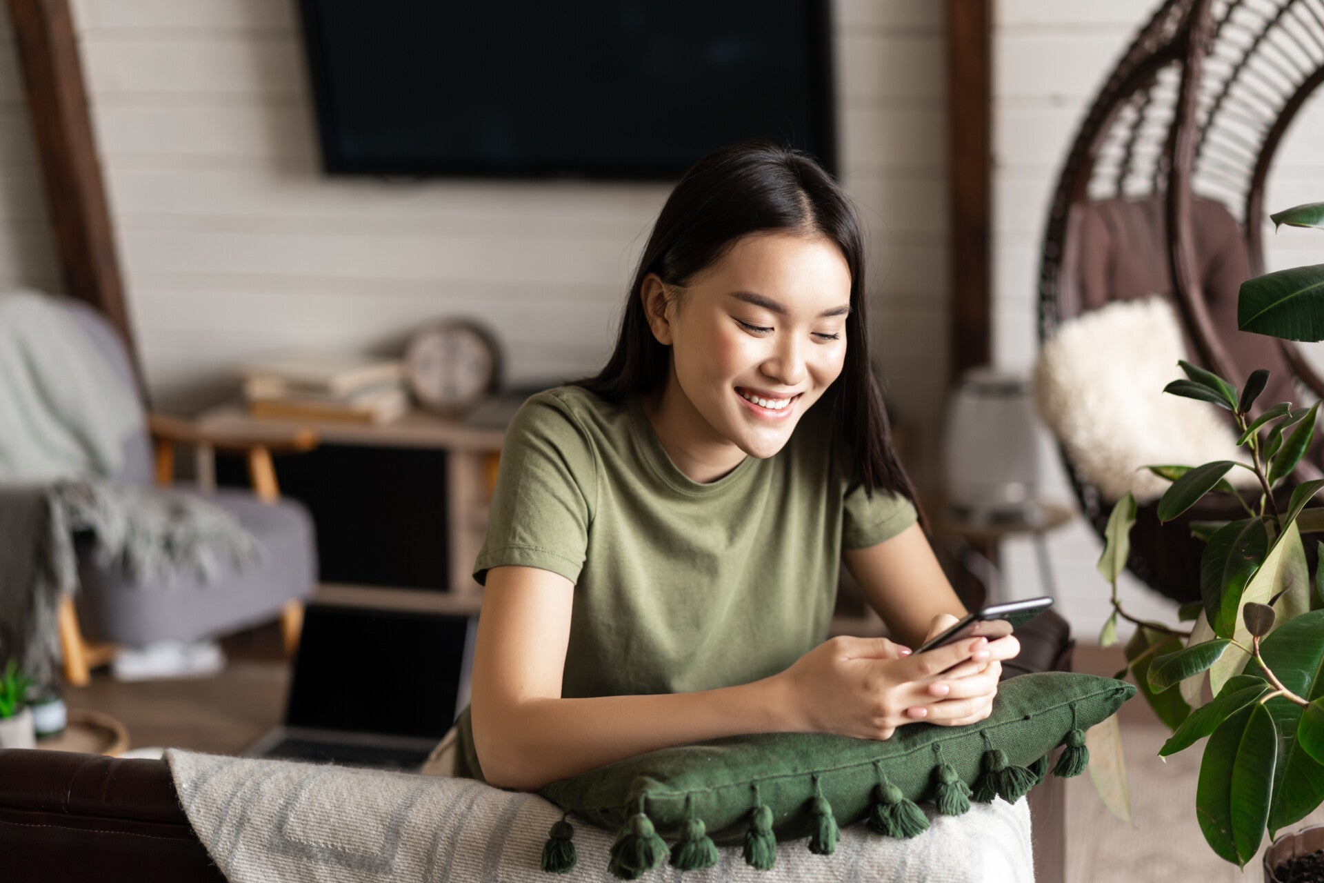 Smiling Korean Girl Chatting Mobile Phone Sitting Home Living Room With Smartphone Laug