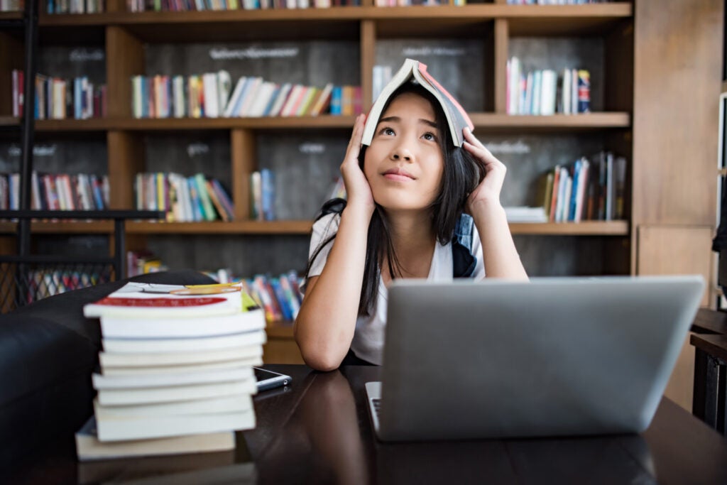 young woman reading book sitting indoor urban cafe