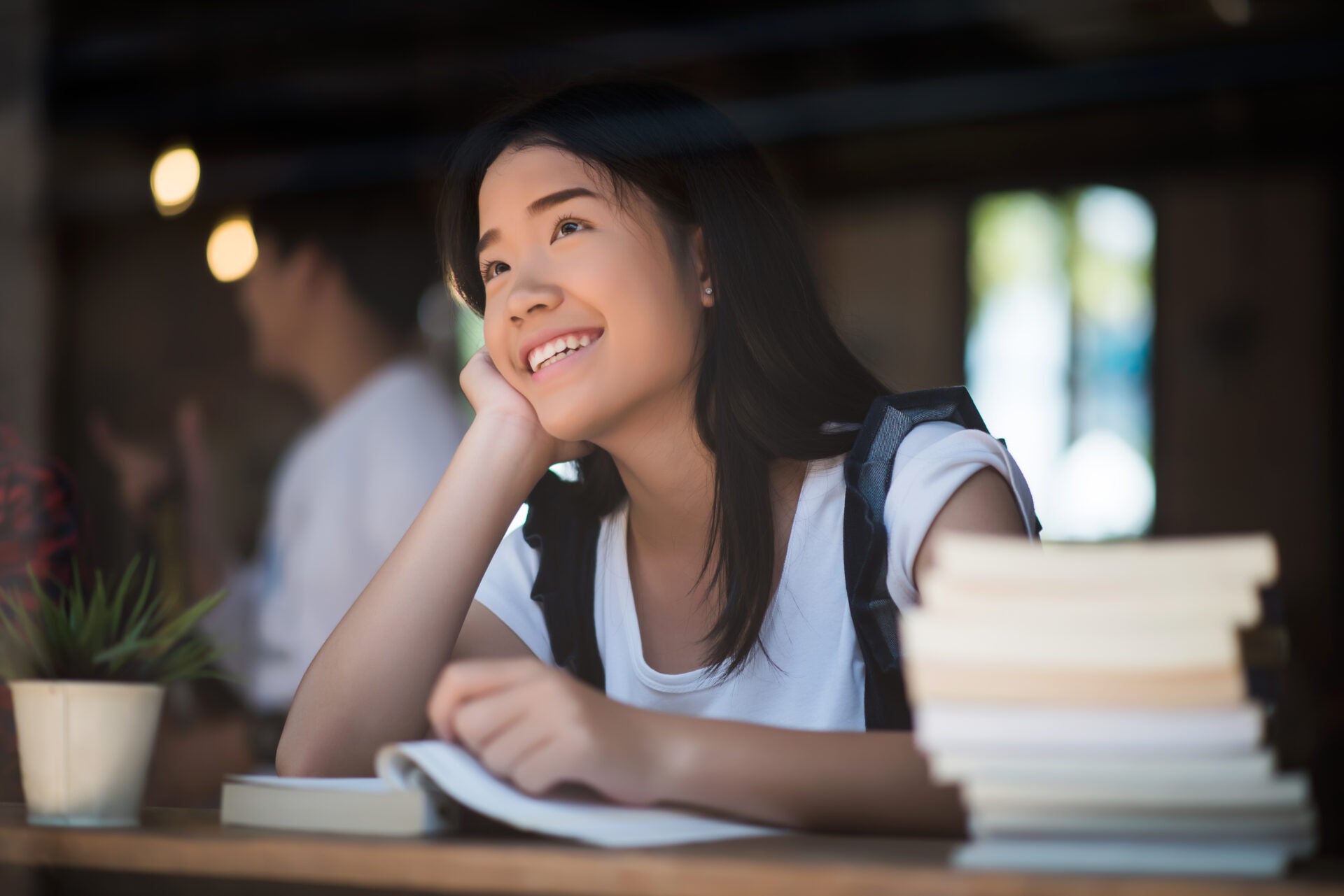 young woman reading book sitting indoor urban cafe