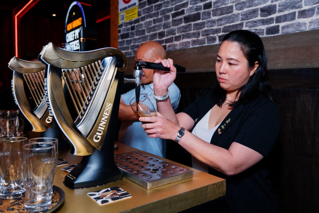 Chief Pint Officer CPO finalist Chia Pui Kwun demonstrating her pouring skills with a perfect pint of Guinness Draught one of the live challenges assessed by Guinness ambassadors