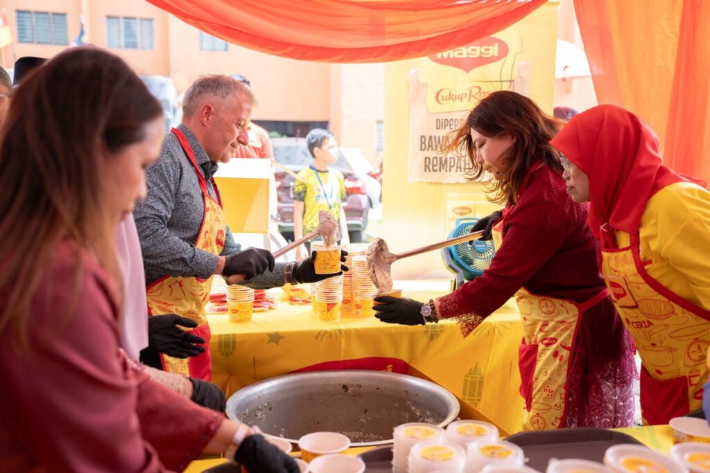 Cik Ivy Tan Link Cheh Dan Encik Juan Aranols Membungkus Bubur Lambuk